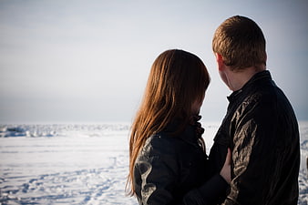 Couple embracing in winter landscape with snowy background