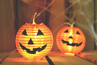 Glowing Halloween Pumpkin Lanterns on Wooden Surface