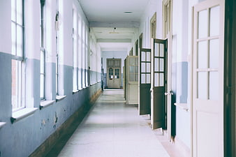 Empty vintage hallway with open doors and blue walls