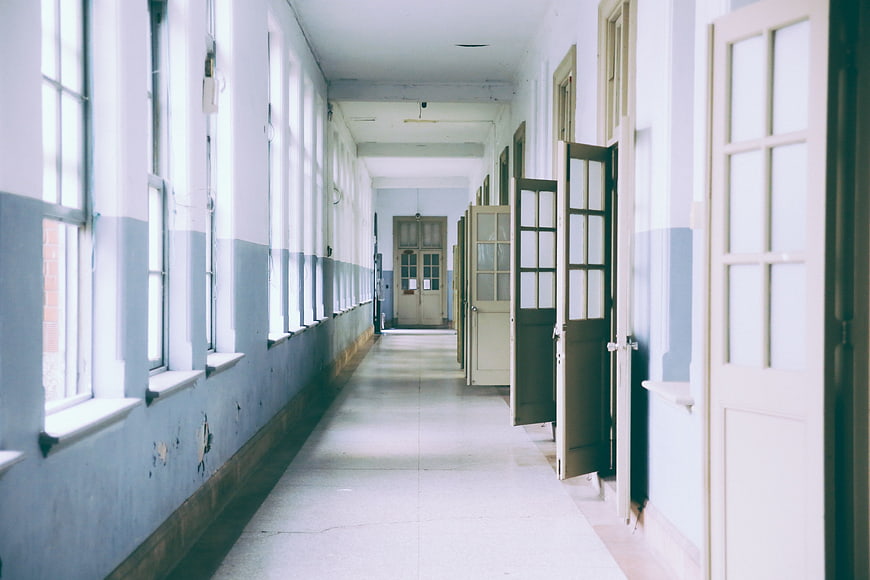 Empty vintage hallway with open doors and blue walls
