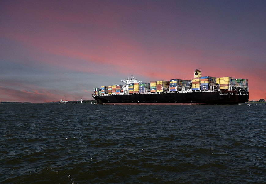 Container Ship Sailing on River at Sunset