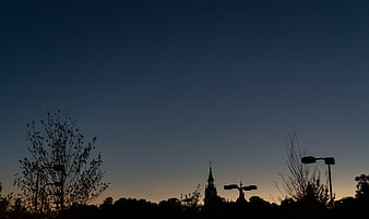 Silhouette of Church Spire and Trees Against Dusk Sky