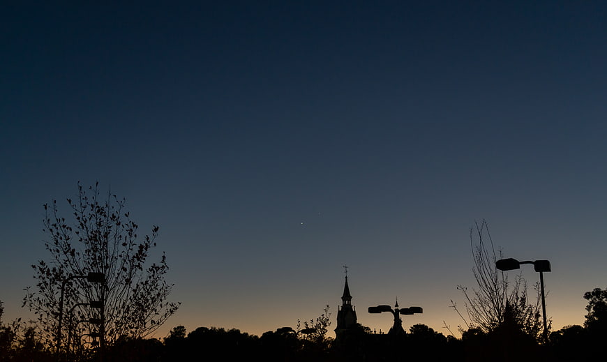 Silhouette of Church Spire and Trees Against Dusk Sky