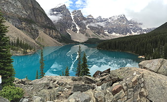 Turquoise Mountain Lake with Snowy Peaks and Forest Reflection