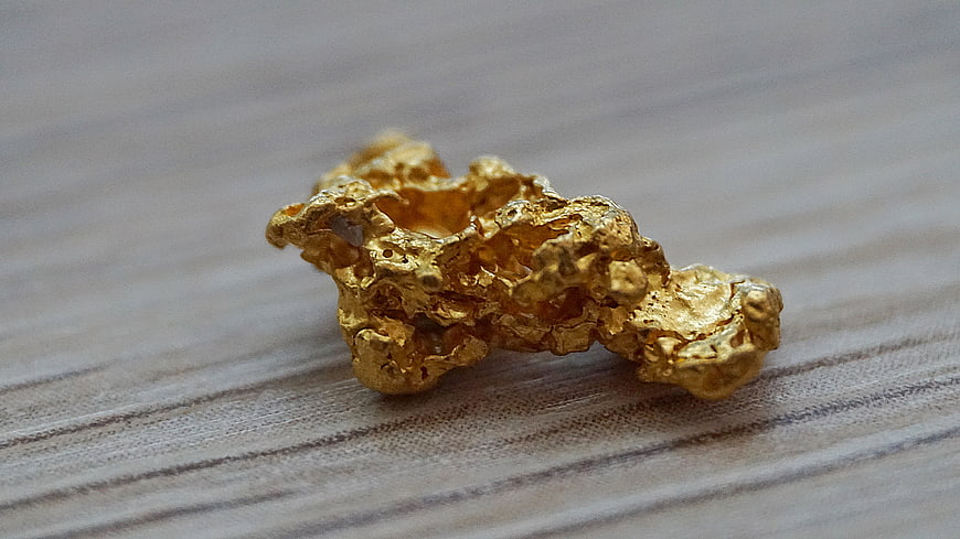 Raw Gold Nugget on Wooden Surface