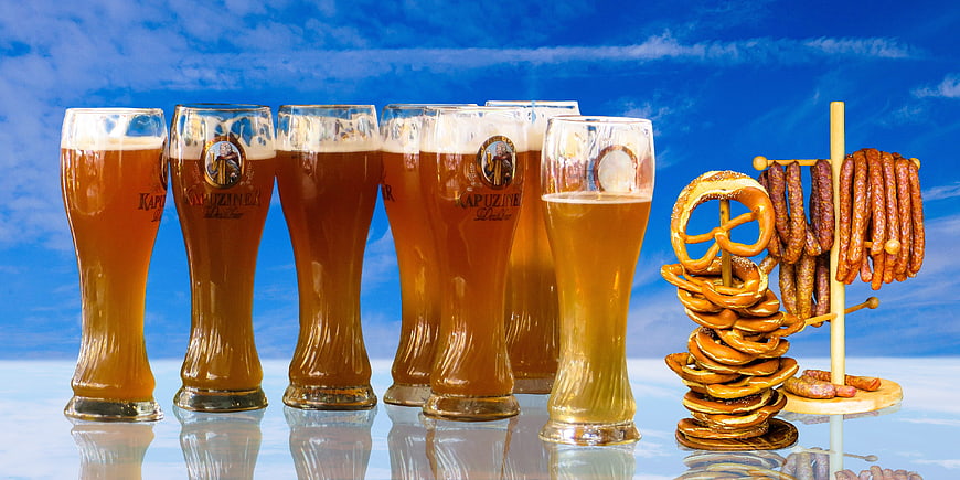 Bavarian Beer Glasses, Pretzels, and Sausages Against Blue Sky