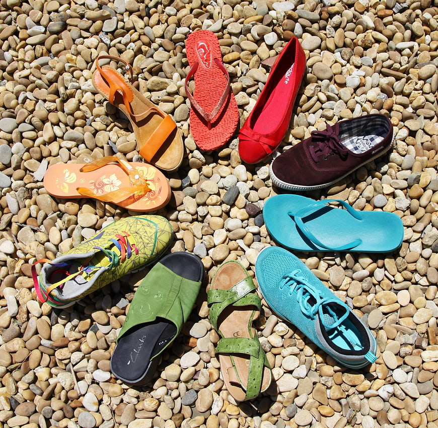 Colorful summer shoes arranged on pebbles