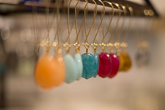 Colorful gemstone earrings hanging on a display rack