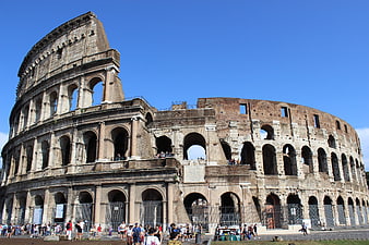 Colosseum in Rome, Italy, with tourists under a clear blue sky
