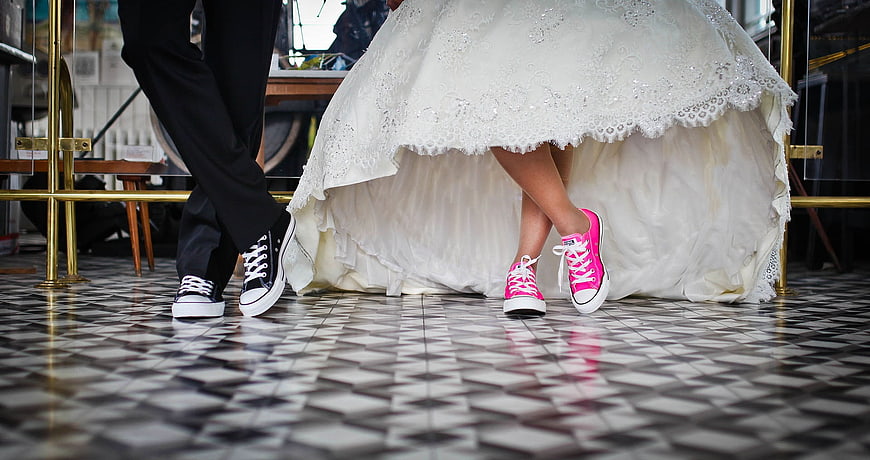 Bride and Groom Wearing Sneakers Under Wedding Dress