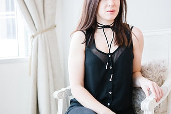 Woman in Black Top Sitting on White Armchair