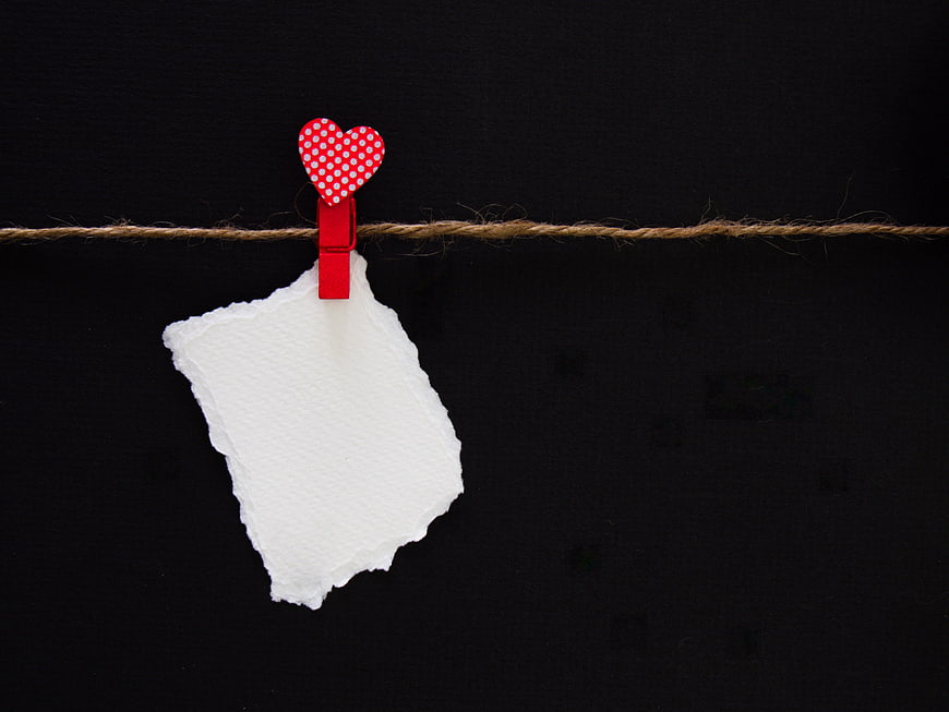 Red Heart Clothespin Holding Torn Paper on Twine