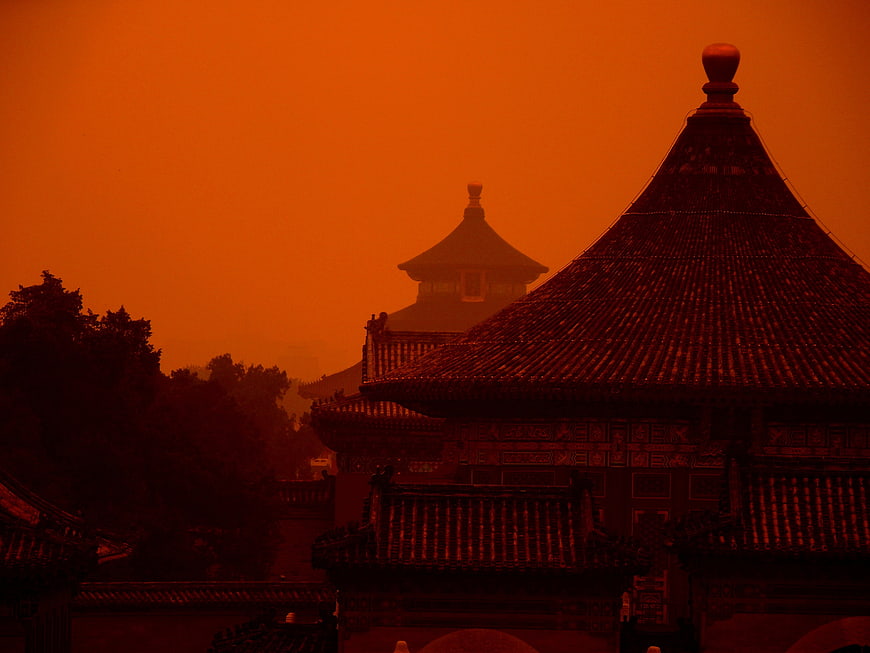 Traditional Chinese Temple Architecture Silhouetted Against Orange Sky