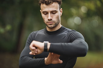 Athletic man checking smartwatch in park