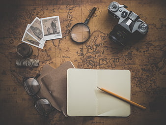 Vintage travel planning flat lay with old map, camera, and notebook