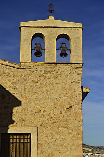 Stone Church Bell Tower Against Blue Sky