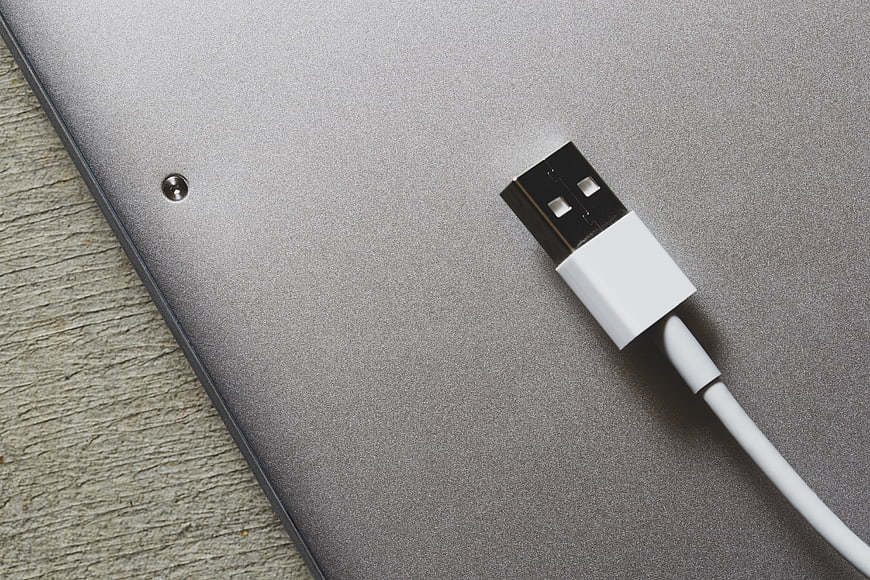 Close-up of USB Cable on Silver Laptop Surface