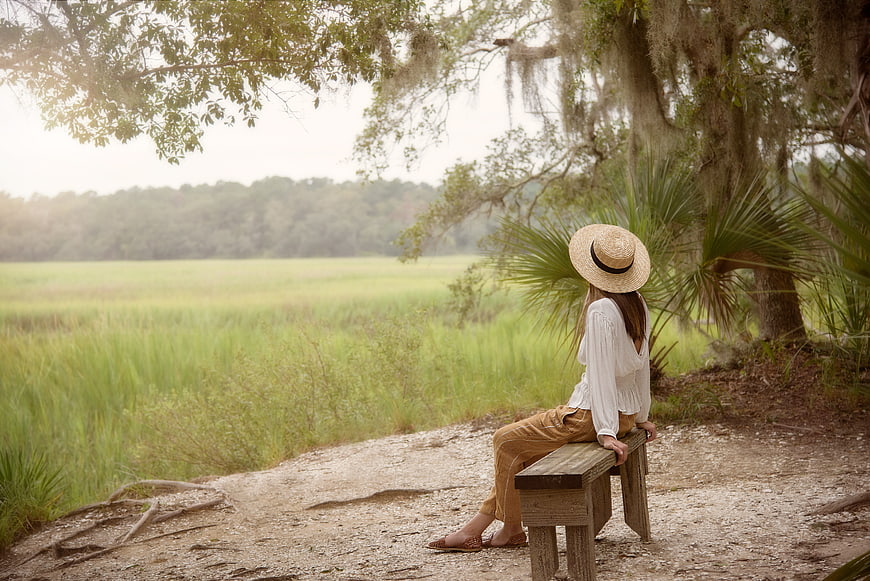 Woman in Straw Hat Sitting on Bench in Nature