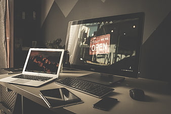 Modern workspace setup with laptop, monitor, and tablet