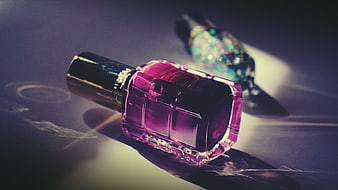 Pink and Blue Nail Polish Bottles on Dark Surface