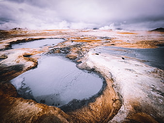 Geothermal hot springs landscape with steam and mineral deposits