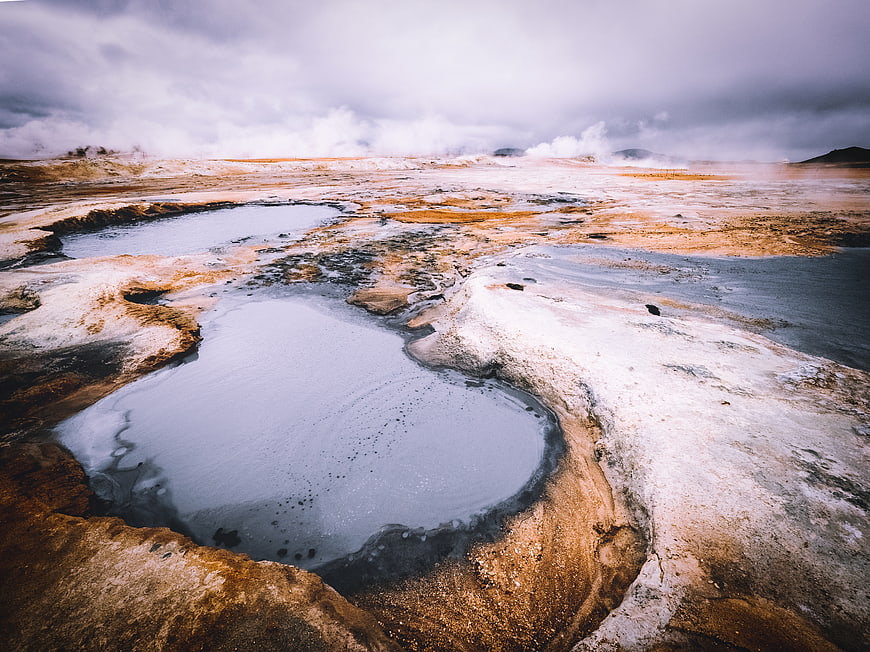 Geothermal hot springs landscape with steam and mineral deposits