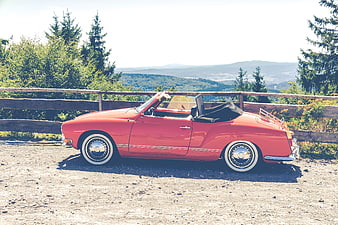 Red vintage convertible parked on scenic mountain overlook