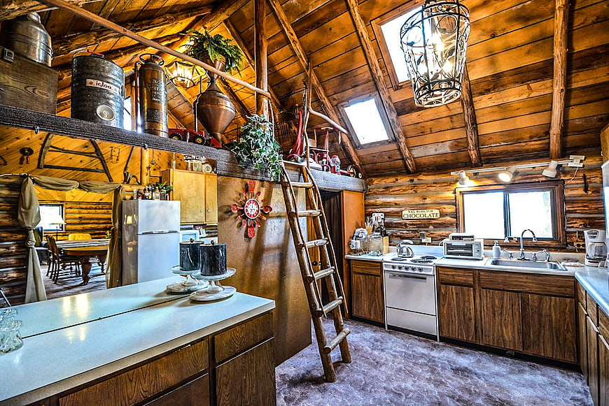 Rustic Log Cabin Kitchen With Vaulted Ceiling, Ladder, and Vintage Decor