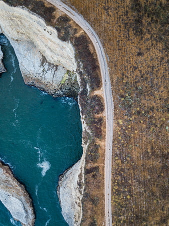 Aerial view of coastal road along rugged cliffs and ocean