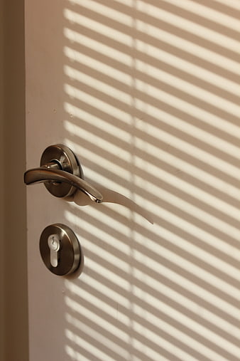 Close-up of door handle with striped shadow pattern