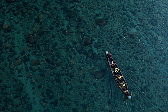 Aerial view of longtail boat in clear turquoise water