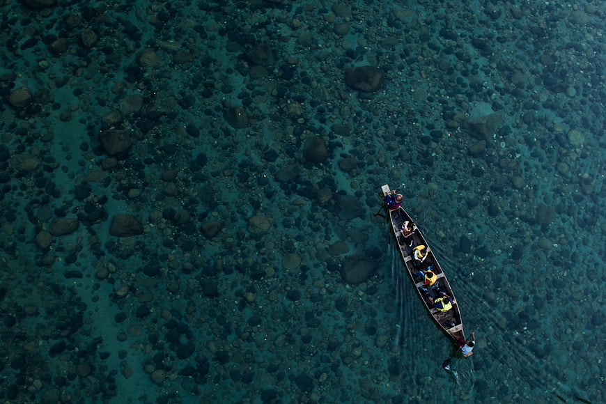 Aerial view of longtail boat in clear turquoise water