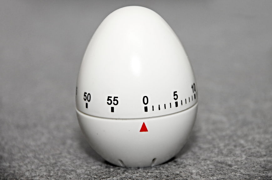 White egg-shaped kitchen timer on gray background