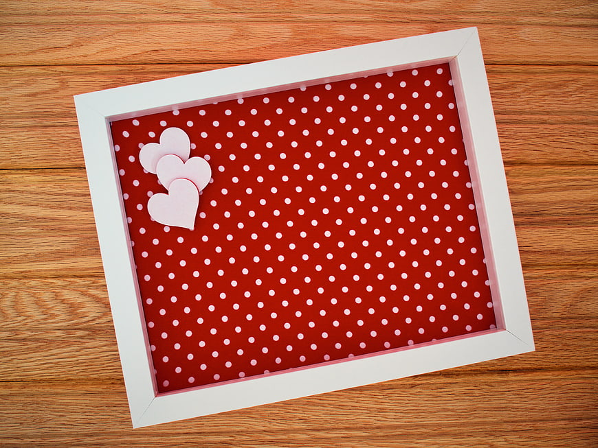 Red Polka Dot Frame with Hearts on Wooden Background