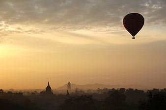 Hot Air Balloon Silhouette Over Ancient Pagodas at Sunrise