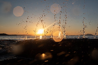 Golden Sunset Splash on Driftwood Log