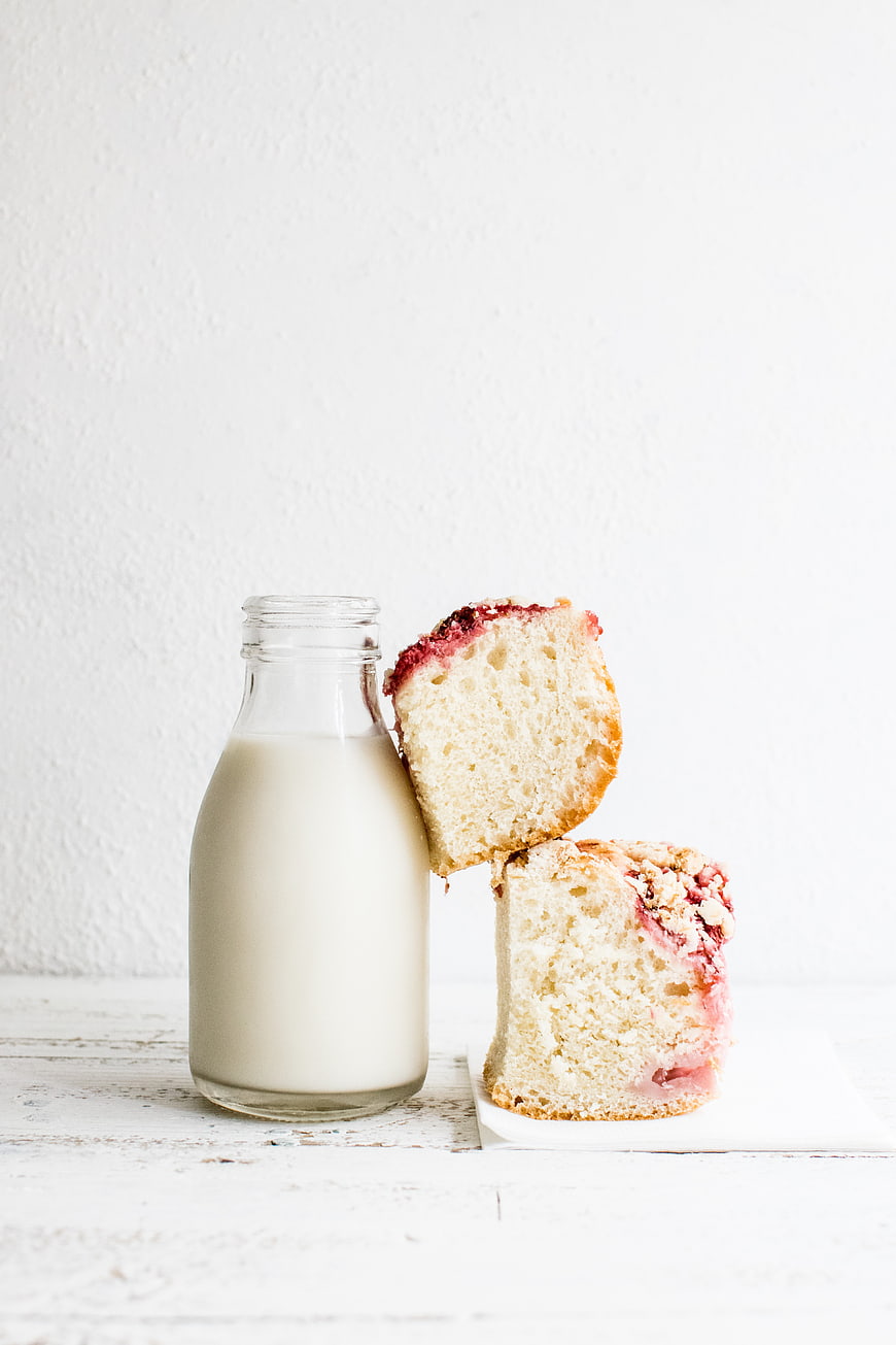 Slices of strawberry crumble cake with glass bottle of milk