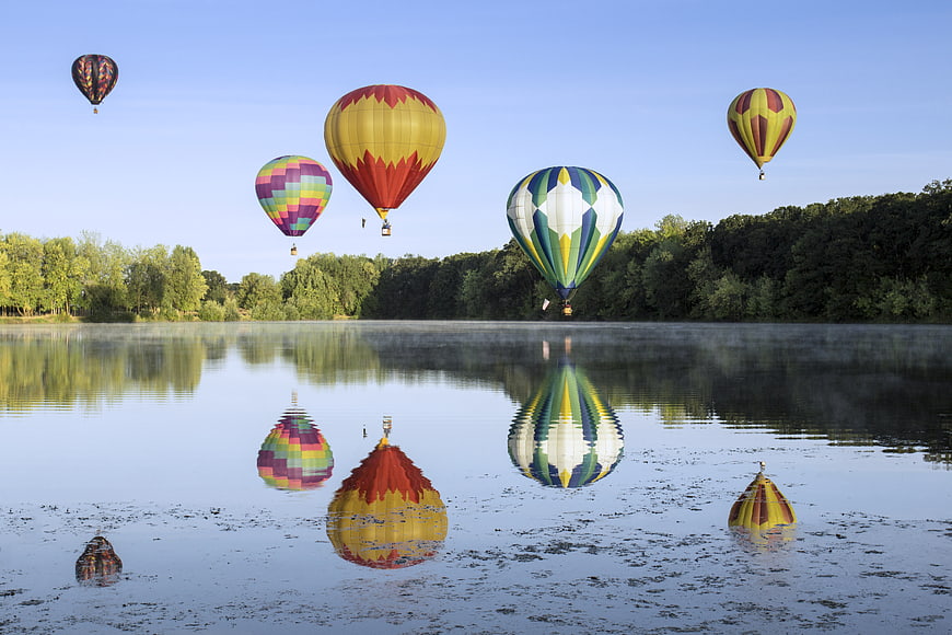 Colorful Hot Air Balloons Reflecting on Misty Lake