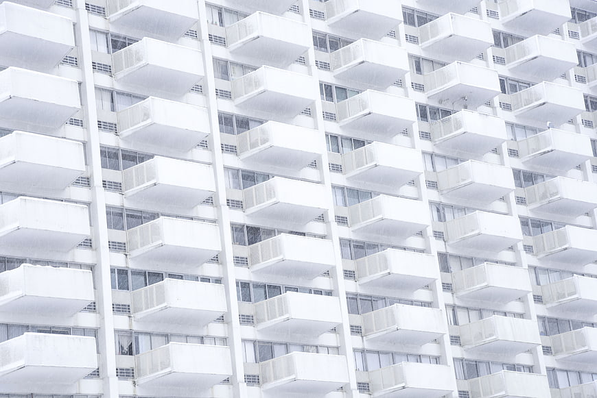 White apartment building facade with repeating balconies