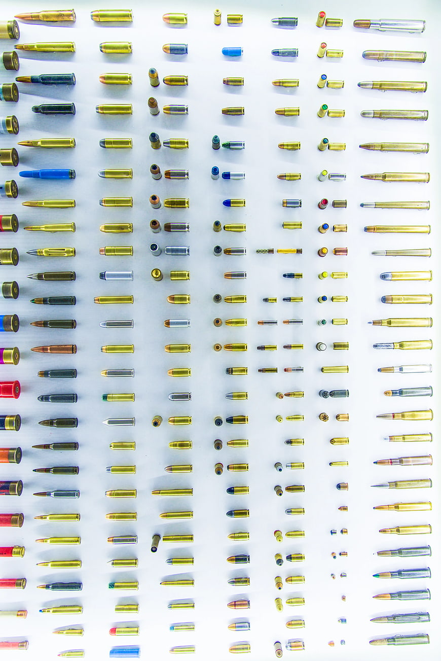 Flat lay of various ammunition cartridges on white background