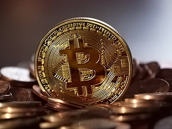 Golden Bitcoin Coin on Pile of Currency