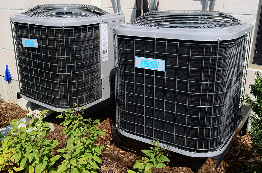 Two KeepRite HVAC outdoor condenser units installed on a residential foundation