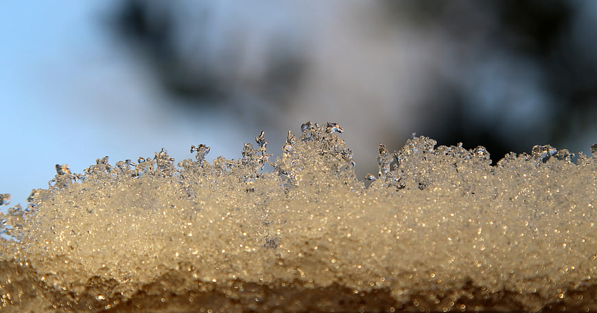 Close-up of sparkling ice crystals on snow surface