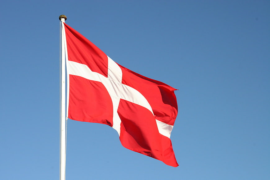 Danish Flag Waving Against Clear Blue Sky