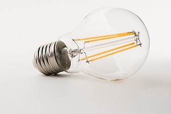 Clear LED filament light bulb lying on a white background