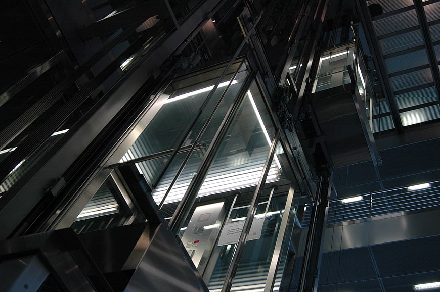 Low angle view of modern glass elevator shaft interior