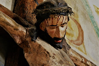 Close-up of weathered wooden Jesus crucifix statue