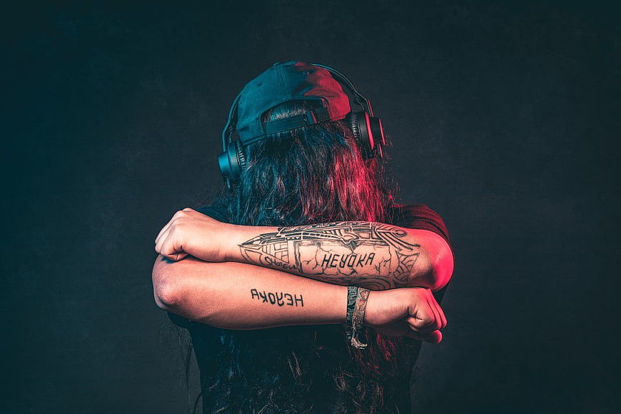 Back View of Musician with Headphones and Tattoos