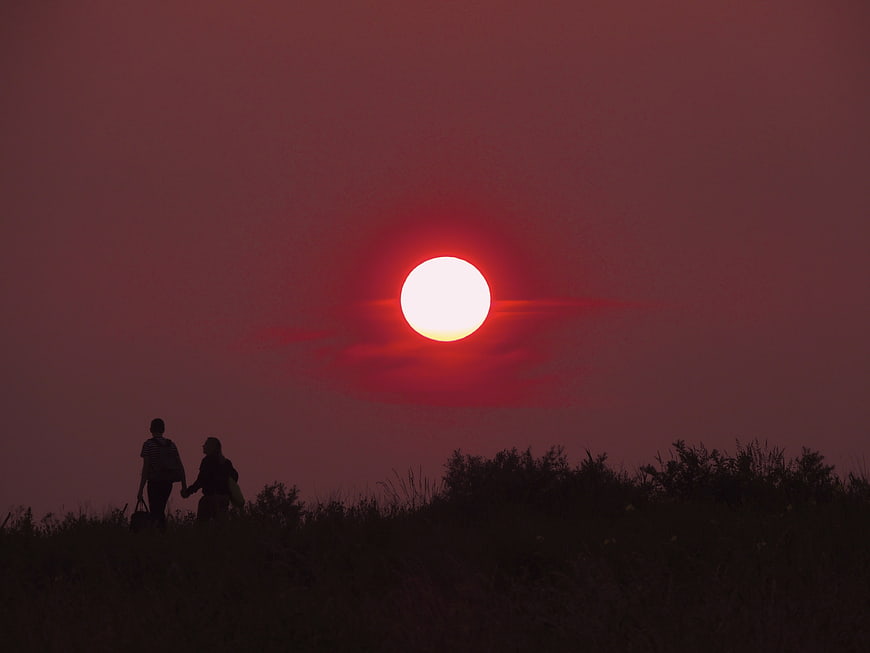 Silhouette of couple walking at sunset