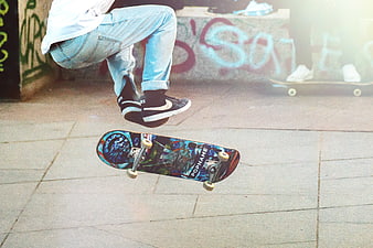 Skateboarder performing a kickflip trick in an urban skatepark